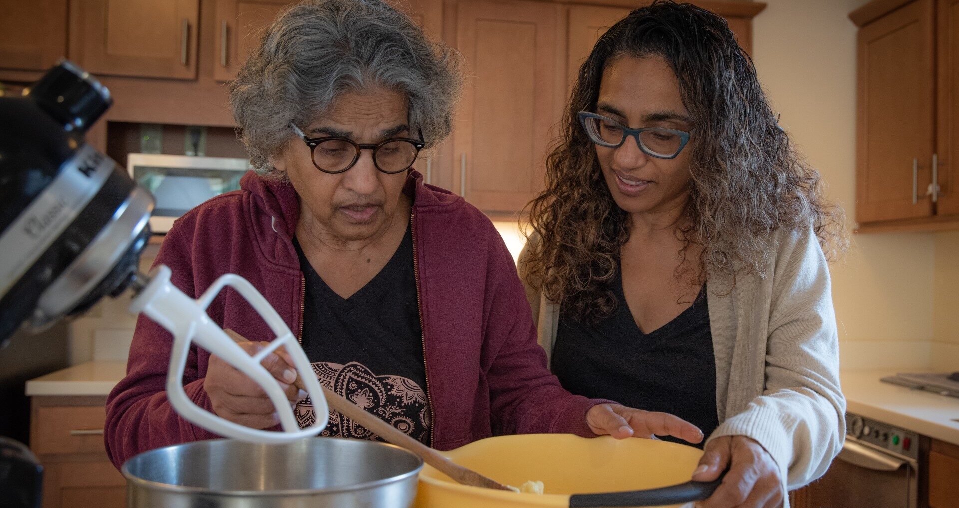 senior woman baking with caregiver