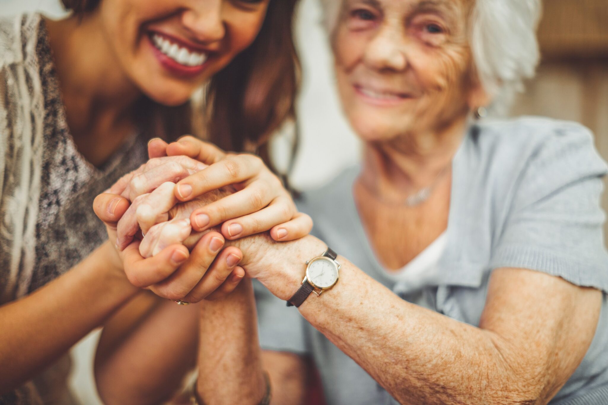 caregiver holding a senior woman's hands