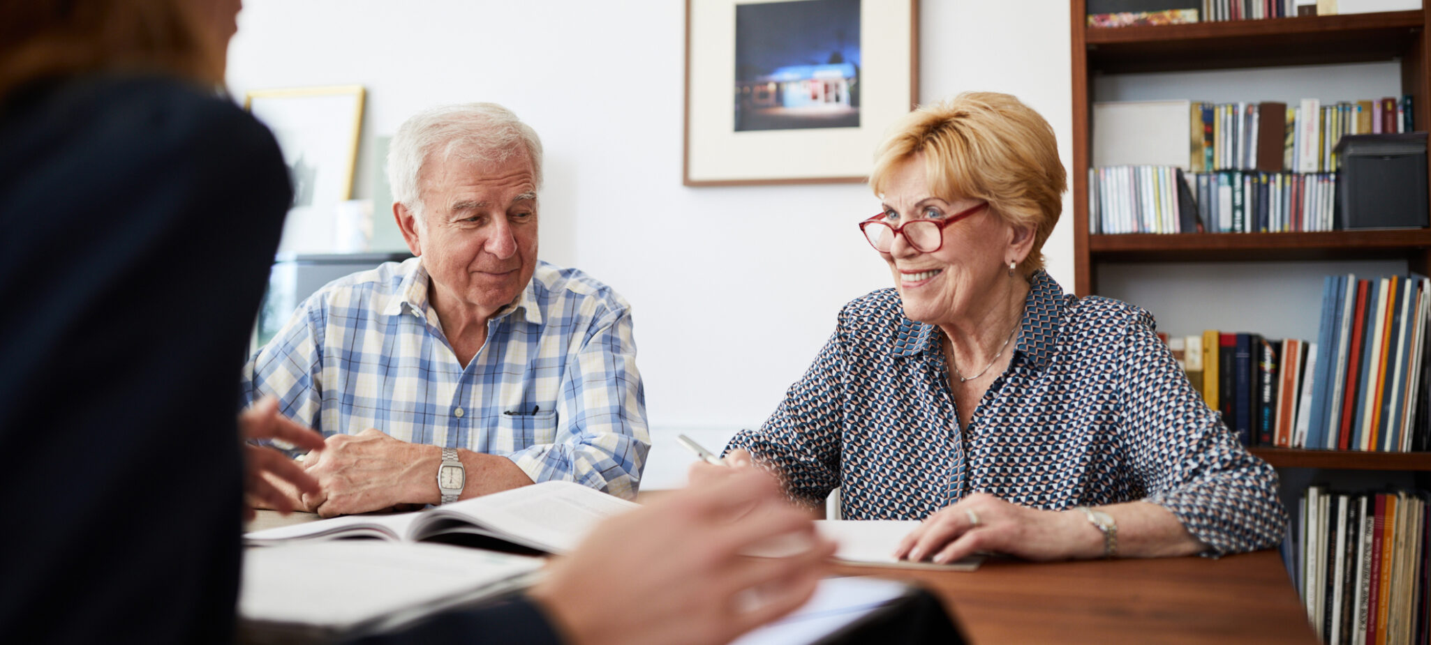 Retired couple meeting with a female financial advisor at home.