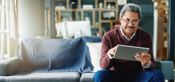 senior man reading on a tablet